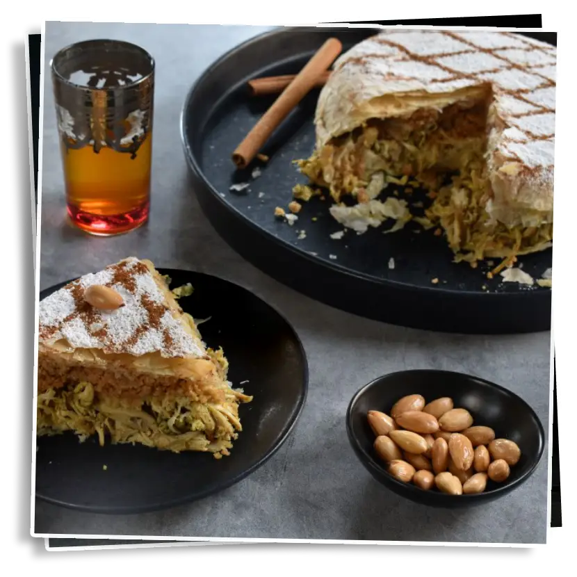 A delicious slice of Moroccan pastilla, a layered pastry filled with spiced chicken or pigeon, topped with powdered sugar and cinnamon, served with almonds on the side.